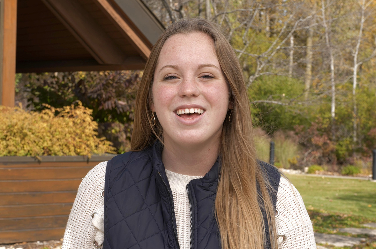 student in front of Founder's Hall